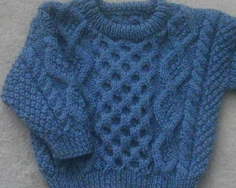 May include: A blue knitted sweater with a cable knit pattern.