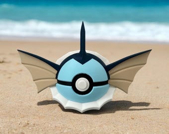 Może przedstawiać: Figurkę Pokemon w kolorze niebieskim i białym z kolczastą płetwą na górze i dwoma dużymi płetwami po bokach. Figurka stoi na piaszczystej plaży.