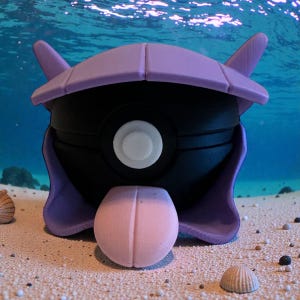 May include: A black and purple 3D-printed sculpture of a Pokémon character, with a white circular detail. The sculpture is set on a sandy surface with seashells and small pebbles, against a backdrop of an underwater scene.