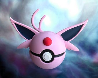 Könnte beinhalten: Ein rosa-schwarzer Pokéball mit einem roten Knopf und einem weißen Kreis in der Mitte. Der Pokéball hat ein Paar schwarze Ohren und zwei rosa Hörner oben.