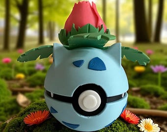 May include: A light blue, spherical figure with a red flower on top and green leaves. The figure has blue markings and a black and white circular design in the centre. The item is a decorative piece.