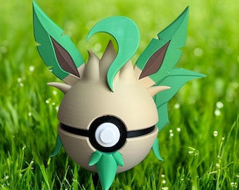 Könnte beinhalten: Eine 3D-gedruckte Figur eines grünen und beigen Pokémon-Charakters mit einem Pokéball-Design. Der Charakter hat große, blattförmige Ohren und einen gekräuselten Schwanz.