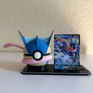 Könnte beinhalten: Eine 3D-gedruckte Pokémon Greninja-Figur mit passender Karte. Die Figur ist blau, schwarz und rosa, und die Karte zeigt eine Greninja V-Illustration. Die Figur und die Karte werden auf einem schwarzen Ständer präsentiert.