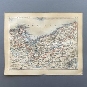 Op de afbeelding: Oude kaart van Pommeren, met gedetailleerde cartografie met rode en blauwe lijnen die regio's en wegen markeren. De kaart bevat Duitse tekst en een kleinere inzetkaart. Het papier heeft een vintage, verouderd uiterlijk.