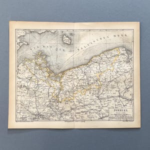 Op de afbeelding: Een antieke papieren kaart van de regio Pommeren, met de Oostzee, gedetailleerde kustlijnen, binnenlandse geografie en wegennetwerken. De kaart bevat de tekst POMMERN, cartografische rasterlijnen en historische labels in het Duits.