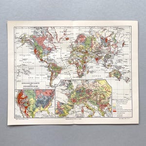 Op de afbeelding: Een vintage geologische wereldkaart gedrukt op papier, met een grote wereldprojectie en twee gedetailleerde inzetkaarten van Noord-Amerika en Europa. De kaart gebruikt verschillende kleuren om geologische formaties aan te duiden en bevat een legenda.