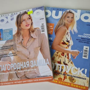 Può includere: Due copertine di riviste con modelle su uno sfondo blu. La rivista si chiama "Burda" e il testo sulle copertine recita "Весь мир моды" e "Сама легкость".