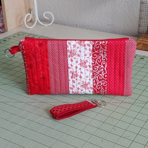 May include: Red and white quilted zippered pouch with a red and black polka dot key chain.