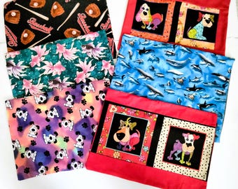 May include: Five different fabric pillow covers with various designs. The covers feature a baseball theme, a fish theme, a dolphin theme, and two dog themes. The covers are all red, black, and white.
