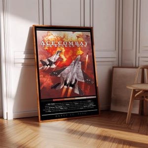 Könnte beinhalten: Ein Poster für das Videospiel Ace Combat: The Belkan War. Das Poster zeigt eine Feuersbrunst mit drei Kampfjets, die durch den Rauch fliegen. Der Text auf dem Poster lautet "Ace Combat: The Belkan War" und "March 23, 2006".