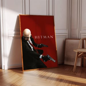 Puede incluir: Un póster para el videojuego Hitman: Absolution. El póster presenta a un hombre con un traje negro y corbata, sosteniendo dos pistolas. El fondo es rojo.