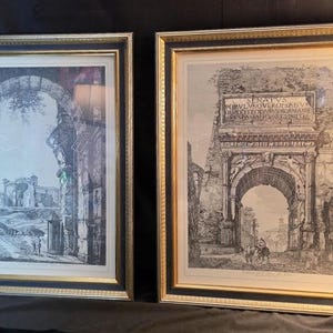 May include: Two framed black and white etchings depicting ancient Roman architectural ruins. Each print is housed in a rectangular frame with a black inner border and a gold outer edge, featuring detailed line work of stone arches and columns.