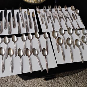 Può includere: Un set di tre tazze in ceramica con finitura opaca e macchiettata. Le tazze sono nei toni del crema, grigio chiaro e grigio scuro. Ogni tazza ha un design semplice e minimalista.