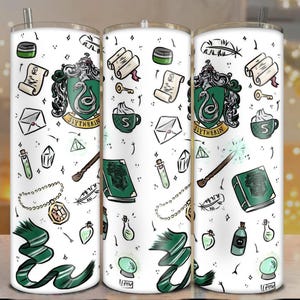 May include: White tumbler with a green and silver Slytherin crest, scrolls, potion bottles, and a wand. The design includes a green and white scarf, a golden key, and a cup of coffee. The tumbler has a silver straw.