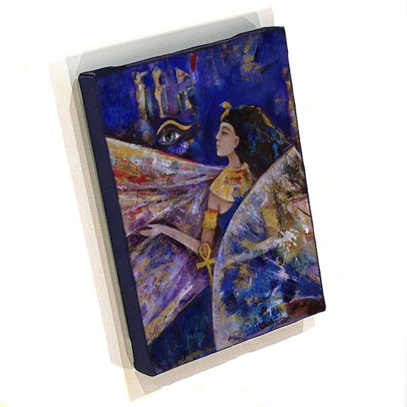 May include: A painting of an Egyptian woman with a golden headdress and a blue and gold robe. The woman is standing in front of a blue background with a large eye and a golden ankh symbol. The painting is done in a colorful and abstract style.