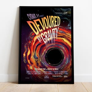May include: A framed poster featuring the title "DEVOURED BY GRAVITY" in bold yellow lettering, set against a vibrant, swirling illustration of a black hole. The poster includes the text "CYGNUS X-1" and the phrase "IT'S DINNER TIME... YOU'RE THE MEAL!"