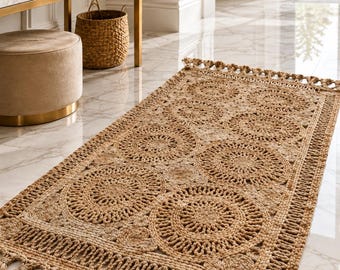 May include: A rectangular woven jute rug featuring a repeating pattern of large circular motifs and smaller circular accents. The rug is finished with a decorative braided border and long, thick tassels along both short ends, showcasing a natural tan colour.