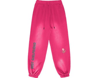 May include: Pink sweatpants with the text "BEST GIRLFRIEND" printed on the left leg and a small embroidered rose on the right leg.
