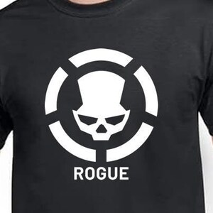 May include: Black t-shirt with a white skull and crossbones logo in a circle. The text "ROGUE" is below the logo.