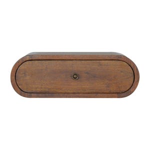 Könnte beinhalten: Ein mittelbraunes Wandregal aus Holz mit einer einzelnen horizontalen Schublade mit abgerundeten Enden. Die Schubladenfront ist glatt mit sichtbarer Holzmaserung und einem kleinen, mittig platzierten runden Metallknopf in Dunkelbronze.