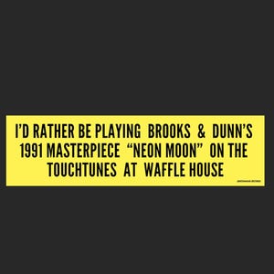 May include: A yellow sign with black text that reads "I'd rather be playing Brooks & Dunn's 1991 masterpiece "Neon Moon" on the TouchTunes at Waffle House."