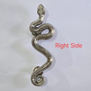 May include: A silver-toned door handle in the form of a snake, featuring intricate scale detailing and a winding shape. The handle is fixed on a white background, with the text "Right Side" in red.