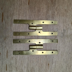 Puede incluir: Dos pares de bisagras de latón con un diseño decorativo. Las bisagras están hechas de latón macizo y tienen un acabado pulido.