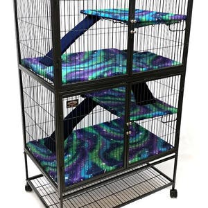 May include: Black metal cage with four levels and a pull-out tray. Each level has a blue and green patterned fabric liner and a ramp. The cage has two doors and is on wheels.
