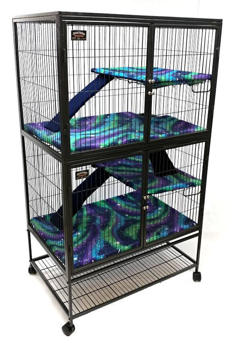 May include: Black metal cage with four levels and a pull-out tray. Each level has a blue and green patterned fabric liner and a ramp. The cage has two doors and is on wheels.