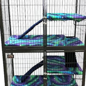 May include: A black metal multi-level cage with a blue, green, and purple patterned fabric lining. The cage has a ramp and a platform.