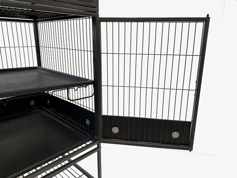 May include: Black metal cage with multiple levels and pull-out trays. The cage has a door that is open.