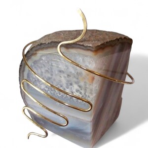 Pu&ograve; includere: Bracciale per braccio in filo d'oro, avvolto attorno a un pezzo di agata. Il bracciale &egrave; realizzato con pi&ugrave; fili, creando un design unico e moderno.