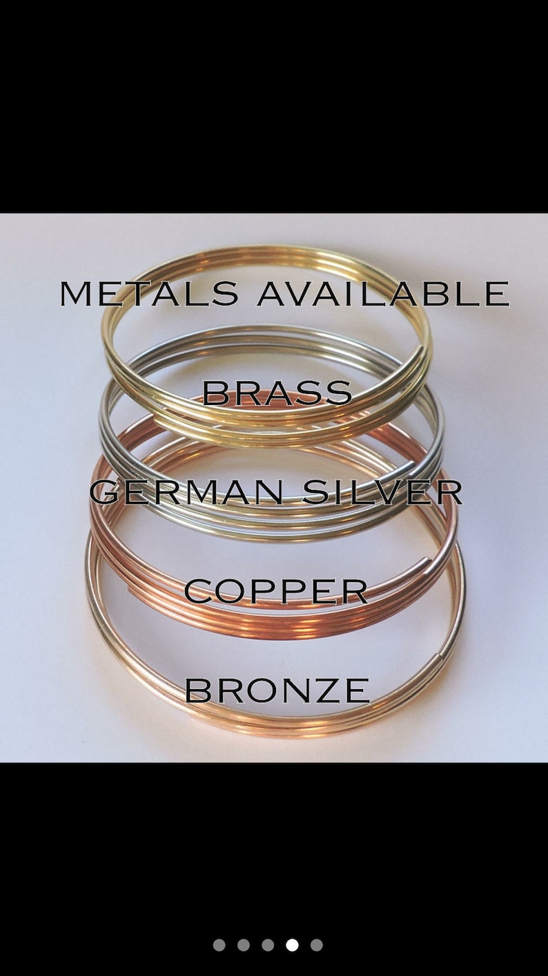 Pu&ograve; includere: Quattro anelli di filo metallico di diversi colori impilati uno sopra l'altro. Gli anelli sono etichettati "Bronzo", "Rame", "Argento tedesco" e "Ottone".