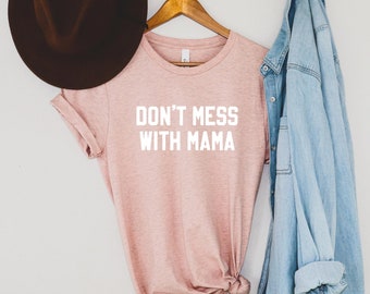 May include: A pink t-shirt with the text "Don't mess with mama" in white lettering.