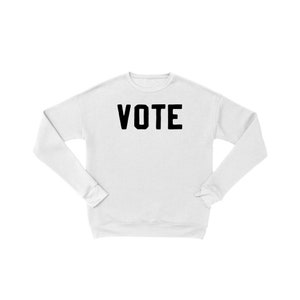 Peut inclure: Sweat-shirt blanc avec le mot "VOTE" imprim&eacute; en noir sur le devant.