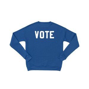 Peut inclure: Un sweat-shirt bleu royal avec le mot "VOTE" imprim&eacute; en blanc sur le devant.