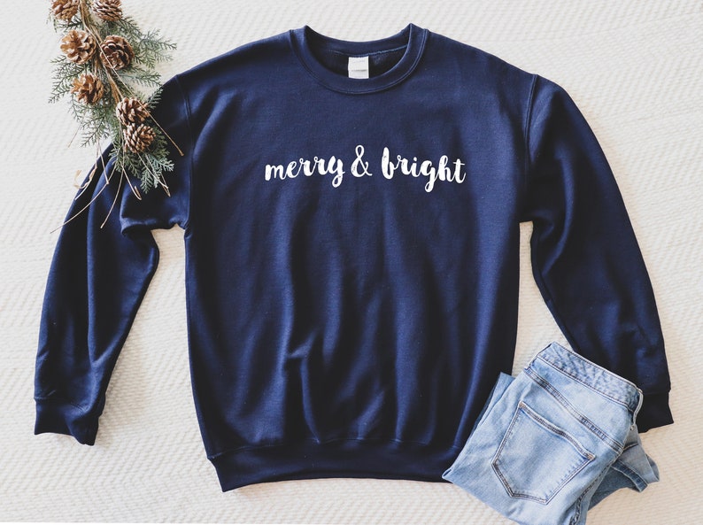 May include: A navy blue sweatshirt with the text "merry & bright" in white lettering.