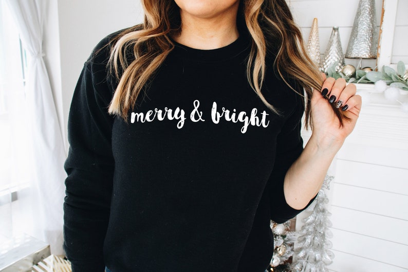 May include: Black sweatshirt with white text that reads "merry & bright".