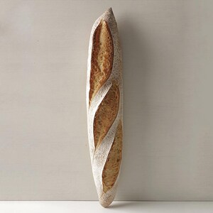 May include: A long, crusty loaf of French bread with a golden brown crust.