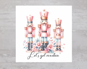 May include: Three pink and gold nutcracker figurines stand in front of a floral arrangement. The text "Let's get crackin'" is written below the figurines.