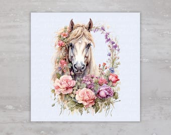 May include: Watercolor illustration of a white horse's head, adorned with a floral wreath of pink, purple, and red roses, and other flowers. The horse has a flowing mane and is set against a light blue background.