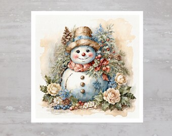 以下が含まれることがあります： 青と白の体をした雪だるまの水彩画。青いバンドのついた茶色の帽子と赤いマフラーをしています。雪だるまは緑の葉、白い花、青いベリーに囲まれています。