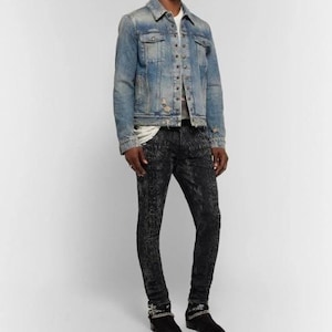 Puede incluir: Chaqueta vaquera azul claro con botones y detalles desgastados. Los vaqueros negros estampados y los botines negros completan el conjunto. El conjunto es informal y elegante.