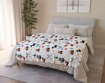 May include: A white blanket with a repeating pattern of cartoon bears, trees, and geometric shapes in various colors. The blanket is draped over a bed with neutral-colored bedding, creating a cozy and inviting atmosphere.