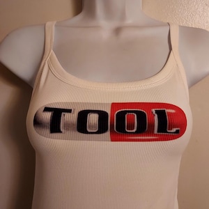 Top sin mangas acanalado con diseño de pastilla, top corto con logo de herramienta y si también lo quieres recortado, solo envíame un mensaje.