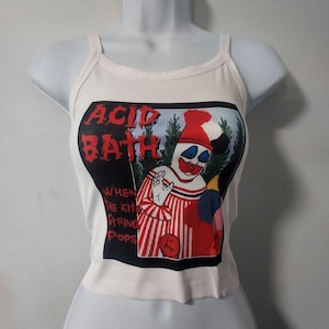 Op de afbeelding: Witte crop top met een zwart-witte afbeelding van een clown met de tekst "Acid Bath" en "When the kite string pops".
