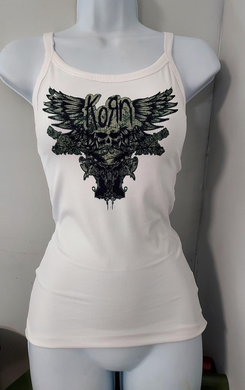 May include: White tank top with a black and green graphic of a skull with wings and the word "Korn" above it.