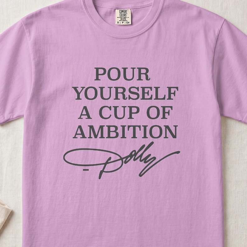 Lavender t-shirt with "Pour Yourself A Cup Of Ambition Dolly" text.