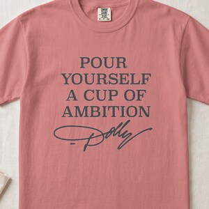 Rose pink t-shirt with "Pour Yourself A Cup Of Ambition Dolly" text.