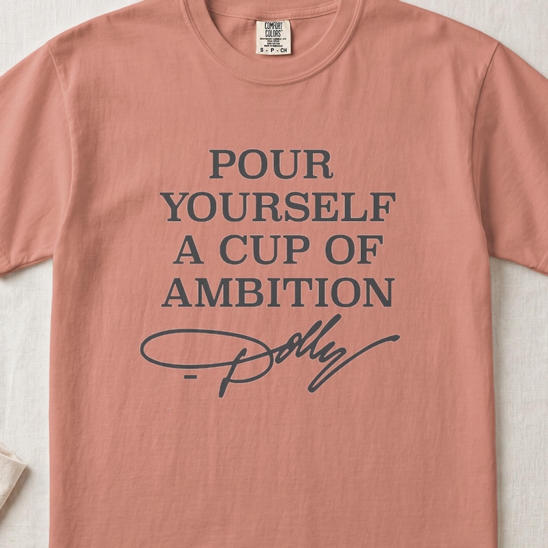 Coral t-shirt with text "Pour Yourself a Cup of Ambition Dolly"